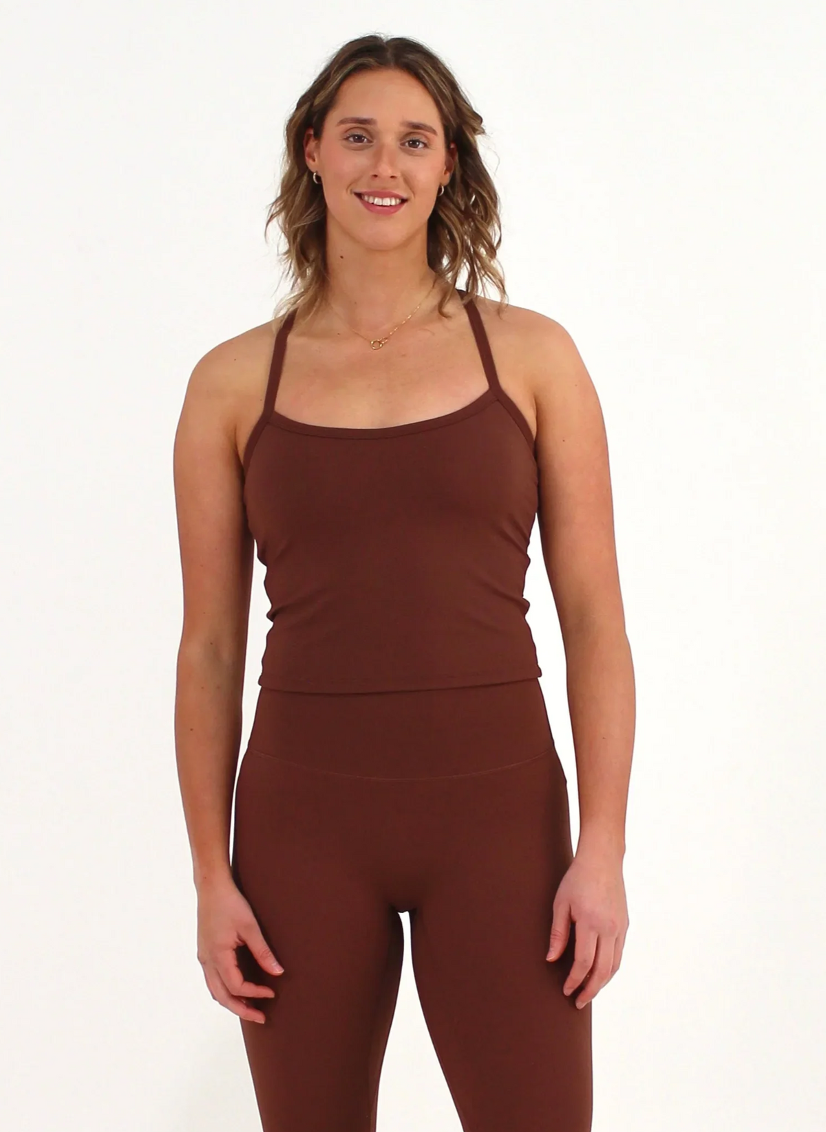 Woman wearing a brown FORM crop top by CAARDEO Active