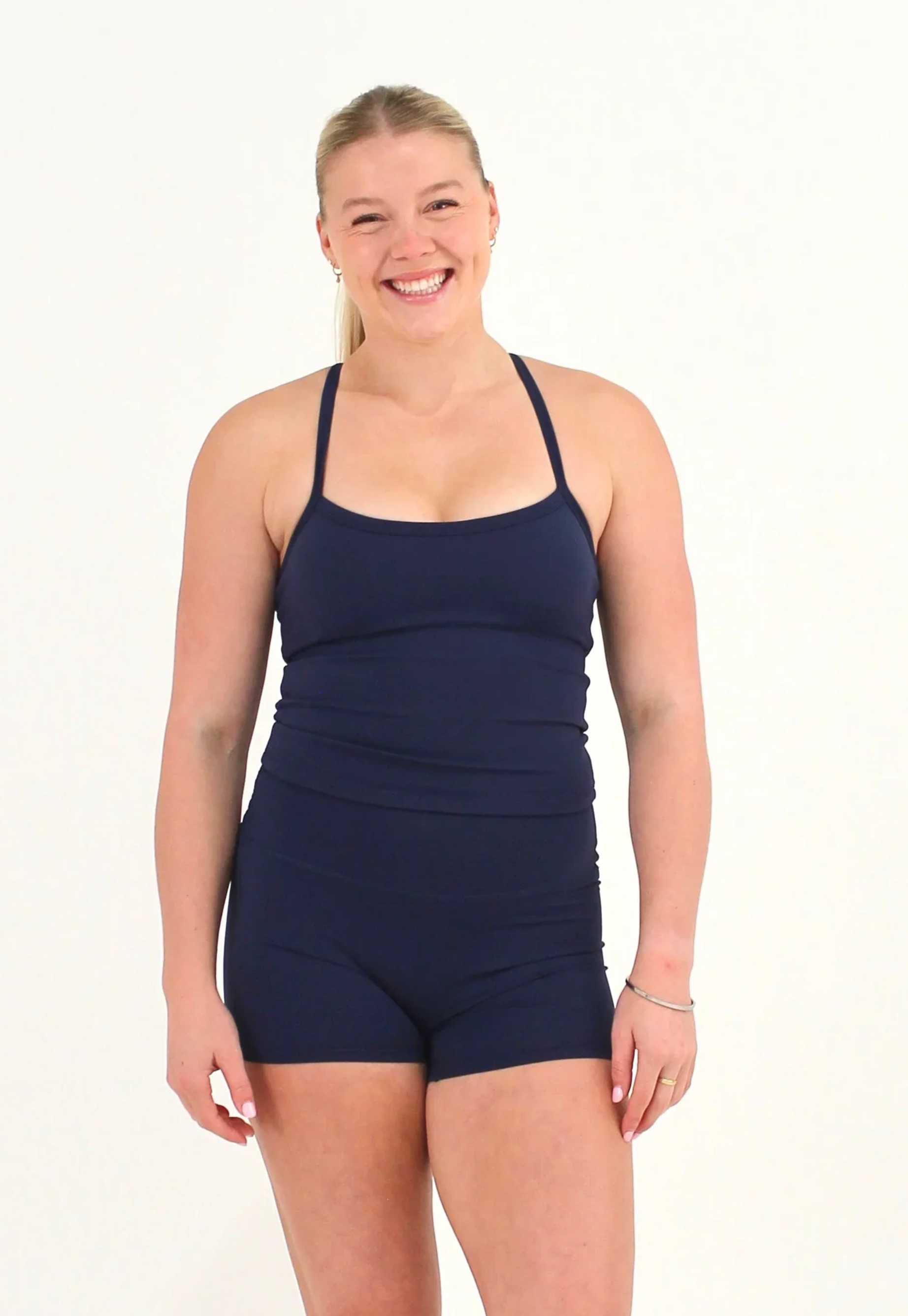 Woman wearing a navy FORM crop top by CAARDEO Active