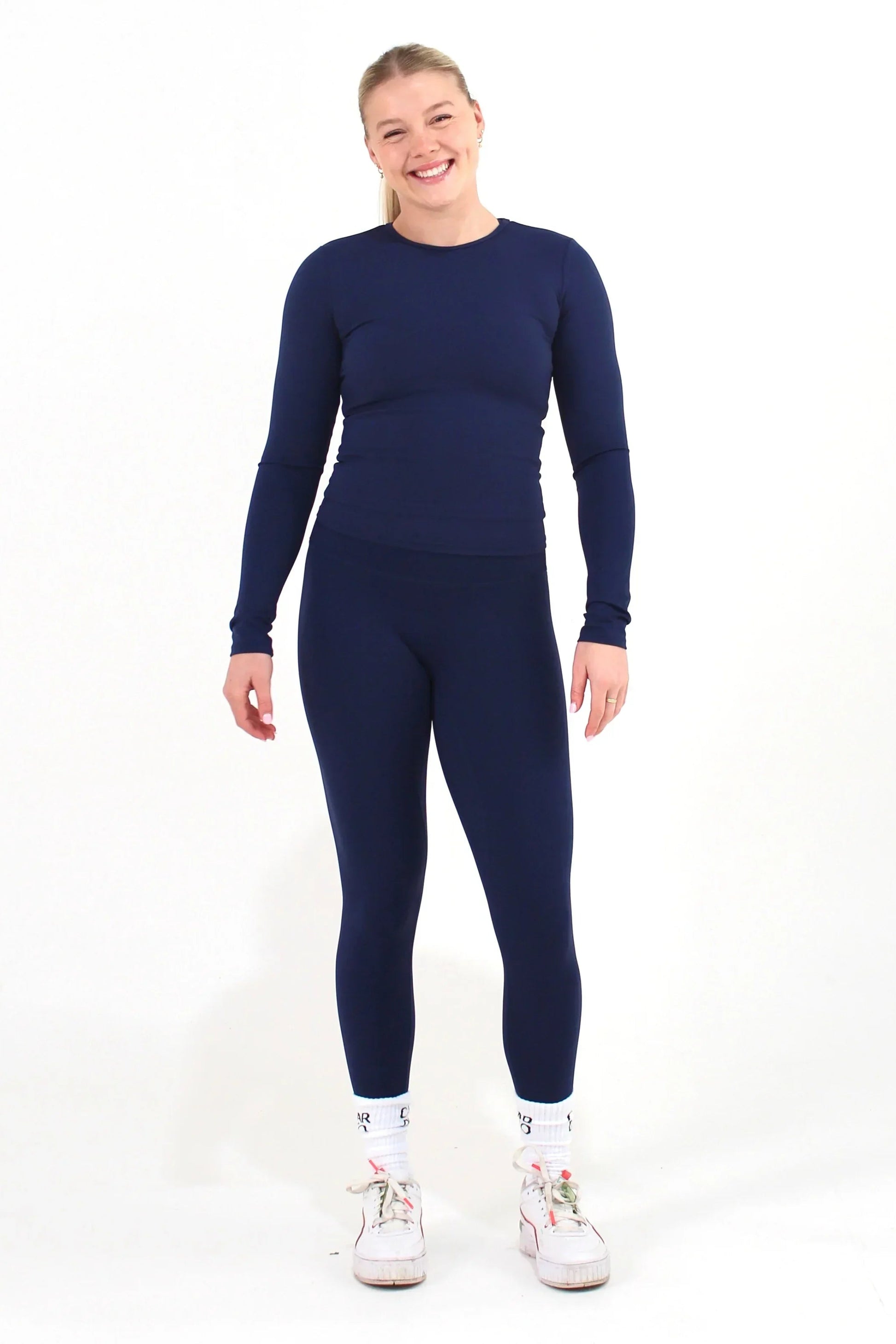Woman wearing a navy FORM long sleeve top by CAARDEO Active