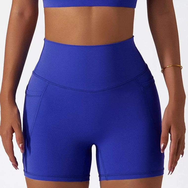 Woman wearing cobalt SECOND SKIN high-waisted shorts with side pockets by CAARDEO Active