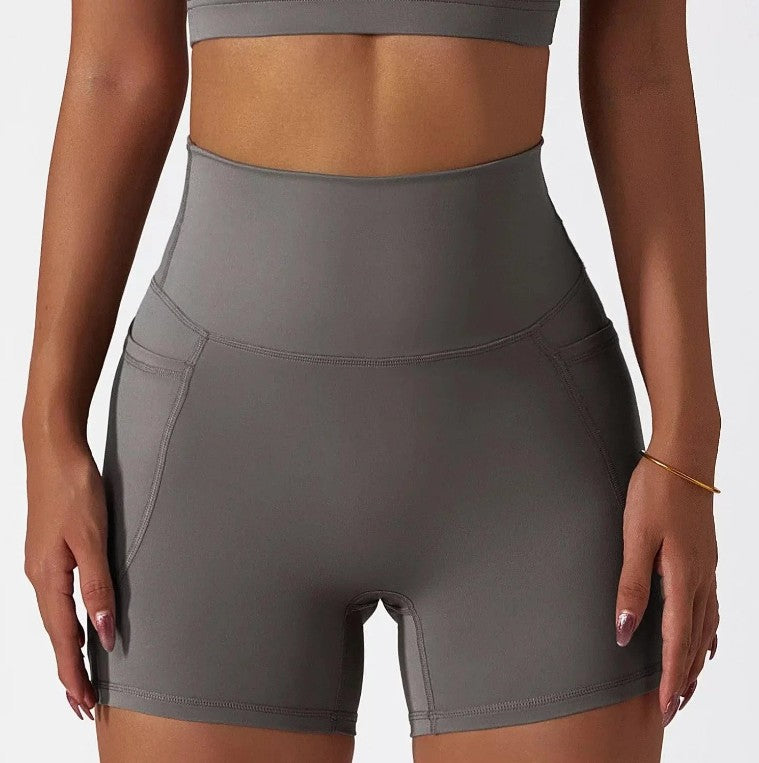 Woman wearing grey SECOND SKIN high-waisted shorts with side pockets by CAARDEO Active