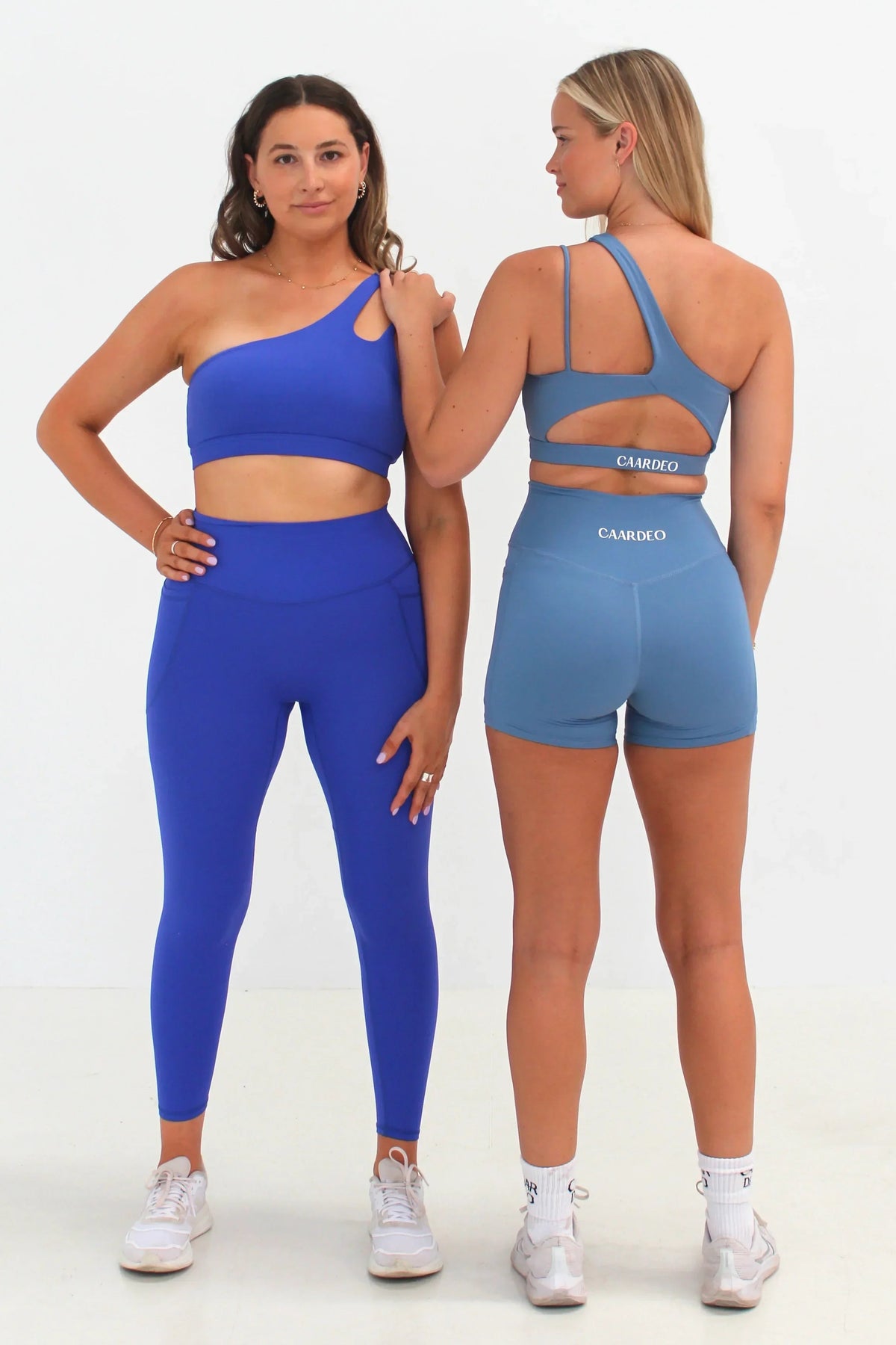 Women wearing blue SECOND SKIN leggings, shorts and crop tops by CAARDEO Active
