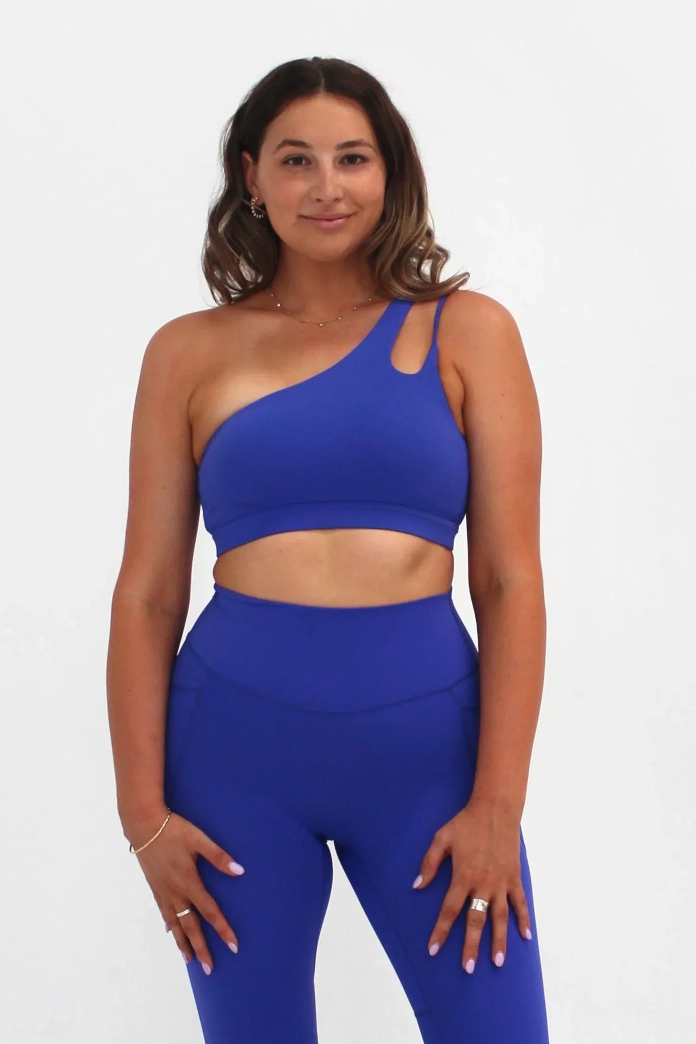Woman wearing cobalt SECOND SKIN Louie asymmetric crop top by CAARDEO Active