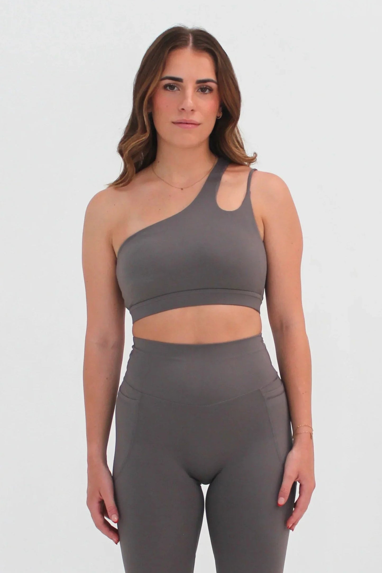 Woman wearing grey SECOND SKIN Louie asymmetric crop top by CAARDEO Active