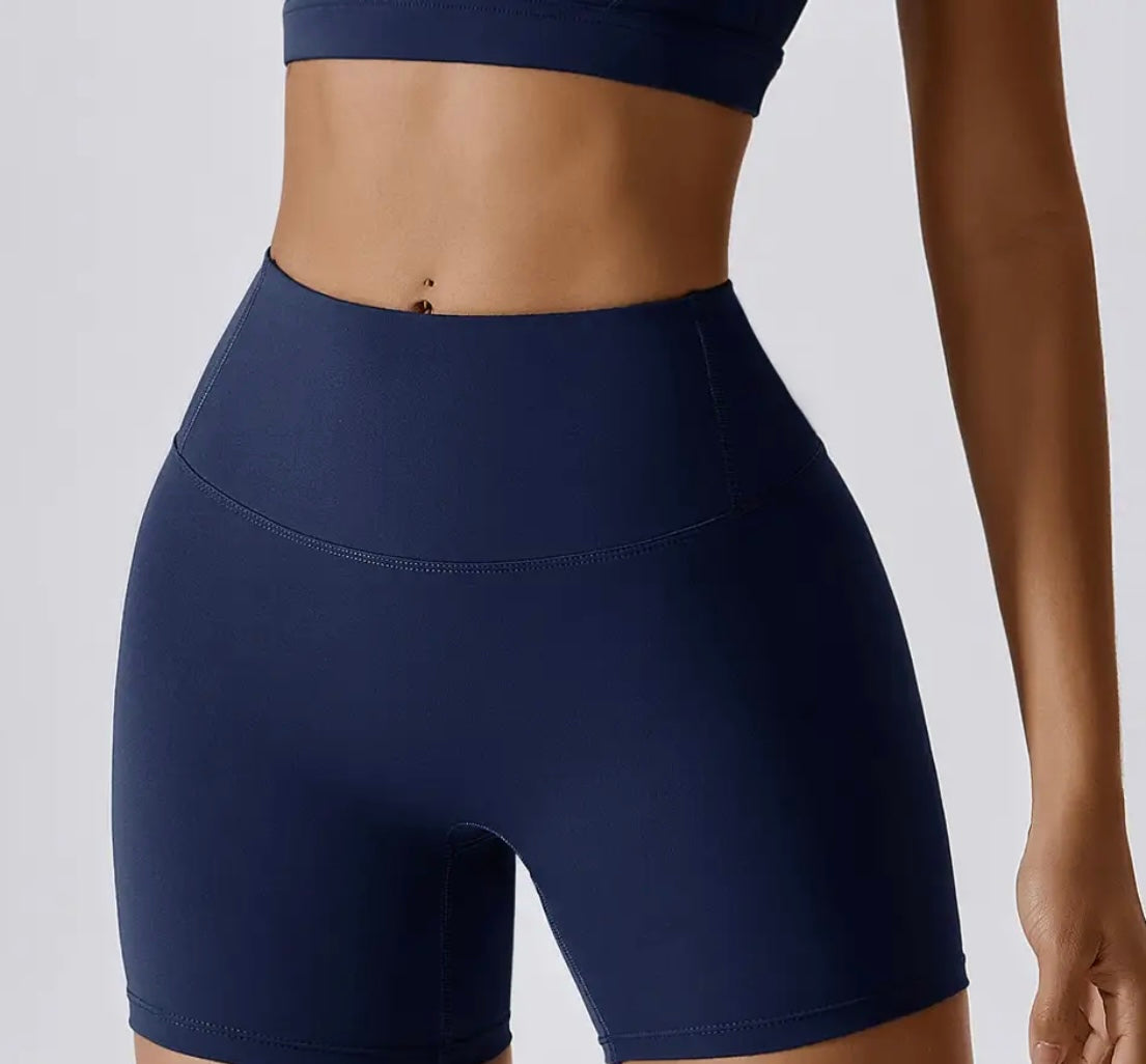 Woman wearing navy high-waisted SCULPT Shorts by CAARDEO Active