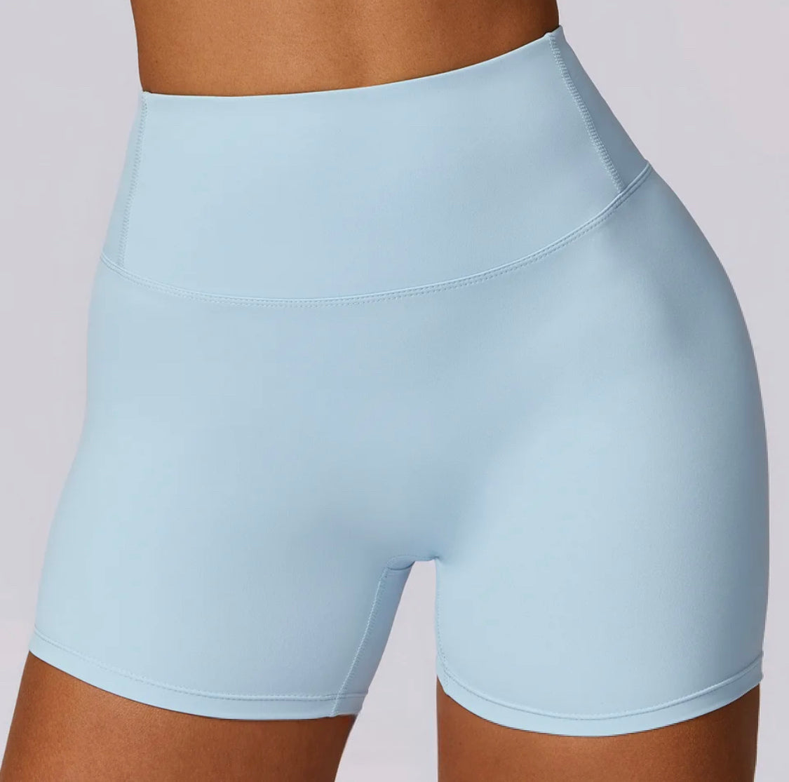 Woman wearing Spring Blue high-waisted SCULPT Shorts by CAARDEO Active