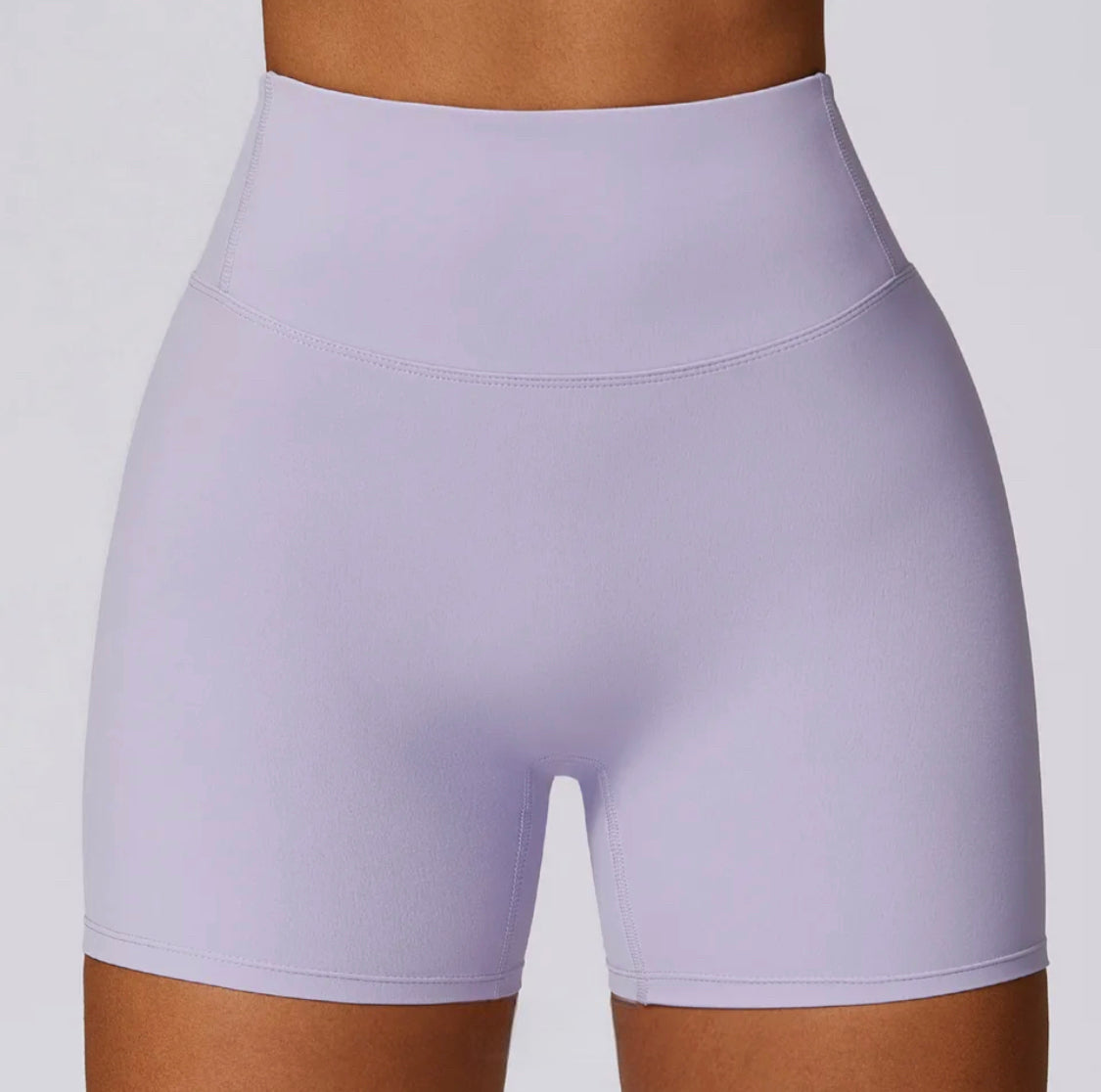 Woman wearing Spring Purple high-waisted SCULPT Shorts by CAARDEO Active