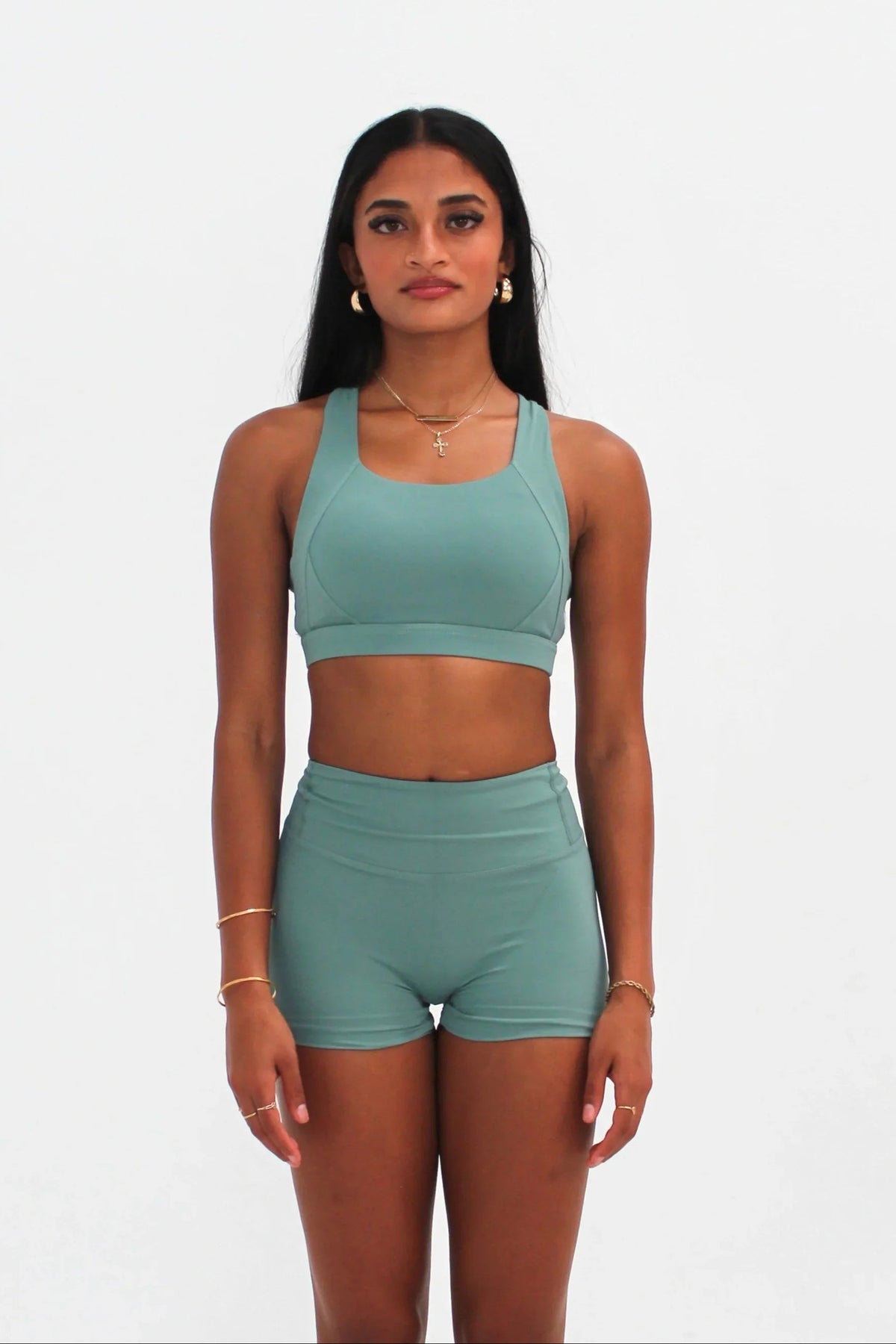 Woman wearing teal high-waisted SCULPT Shorts by CAARDEO Active